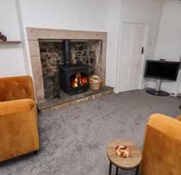 A living room with a fireplace and sofas at 1 Sunnybrae Alnwick