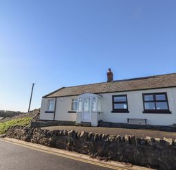 A house with a front door and windows at Harry's Cottage in Embleton