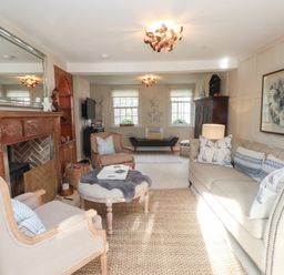 A living room with a sofa, armchair, and coffee table at The Music Box in Beaumaris