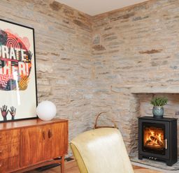 A living room with a fireplace and artwork at Boscabrea near Tintagel
