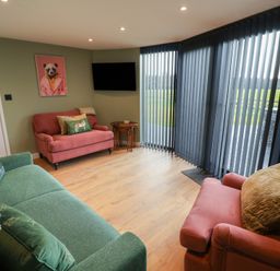 A living room with a television and seating at Unit 1 in Ipswich