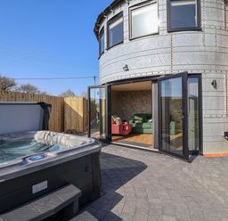 An outdoor area with a hot tub and an entrance to a living room at The Corn Silo in Ipswich