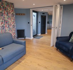 A living room with a sofa and armchair at Unit 2 in Ipswich