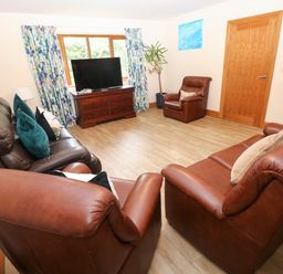 A living room with sofas and a television at Ty-Gan Dderwen, Llangennech, Llanelli