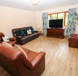 A living room with sofas and a television at Ty-Gan Dderwen in Llangennech, Llanelli