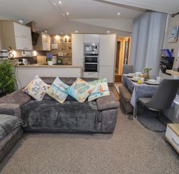 A living room with a dining area and kitchen at Offspray Court 1 in Scratby