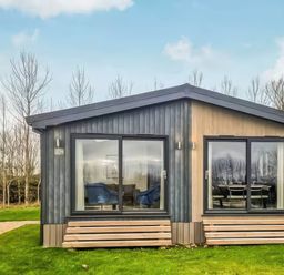 A cabin with large windows and steps at Isca Lodge in Wombleton