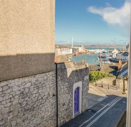 A view of a harbor with boats and houses at Seahorse Cottage in Weymouth