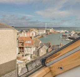 View of the harbor with buildings and water at Seahorse Cottage in Weymouth