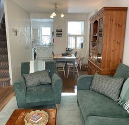 A living room with furniture and a dining area at Seahorse Cottage in Weymouth