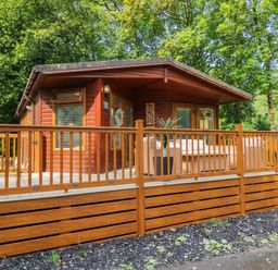 A cabin with a deck and outdoor furniture at Terabitha Lodge Troutbeck