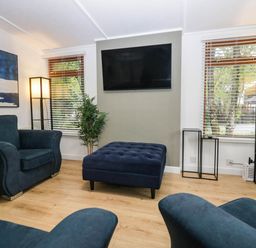 A living room with a sofa and ottoman at Terabitha Lodge in Troutbeck