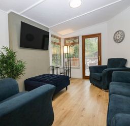 A living room with furniture and a television at Terabitha Lodge in Troutbeck