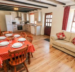 A kitchen with dining table and chairs at Ty Fferm in Newport