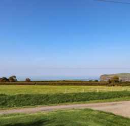 A view of the sea and hills with fields at Ty Felin in Newport
