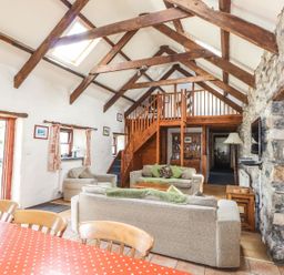 A living room with a staircase and sofa at Ty Felin Newport