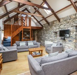 A living room with grey sofas and a wooden coffee table at Ty Felin in Newport, Pembrokeshire