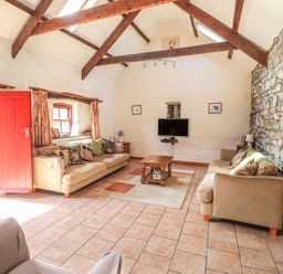A living room with a television and seating area at Ty Gwartheg Newport