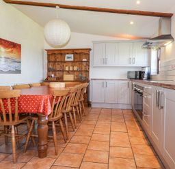 A kitchen with a dining table and chairs at Ty Gwartheg in Newport