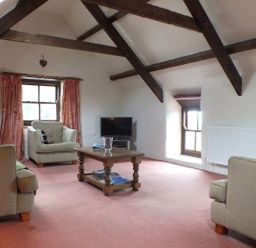 A living room with sofas, a coffee table, and a television at Ty Cariad in Newport