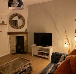 A living room with a sofa and television at Braeburn in Bamburgh