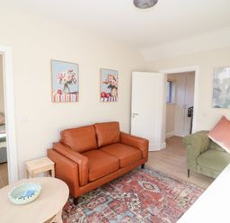 A living room with a brown sofa and rug at Duck Cottage