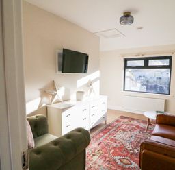 A living room with a sofa and television at Duck Cottage