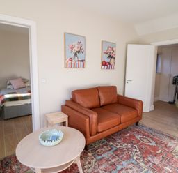 A living room with a sofa and side table at Duck Cottage