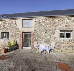 An outdoor area with a table and chairs at Dairy Cottage Bullhornstone near South Brent