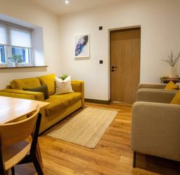 A living room with a sofa and armchairs at Aspen Apartment in Llanrwst