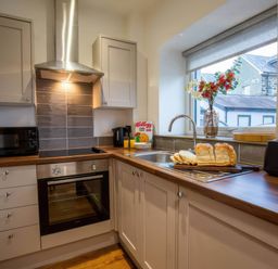 A kitchen with a sink and appliances at Aspen Apartment in Llanrwst