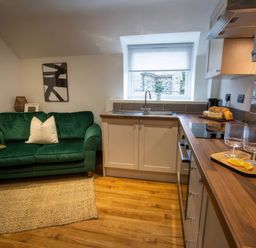 A kitchen with a green sofa and countertop at White Willow Apartment Llanrwst