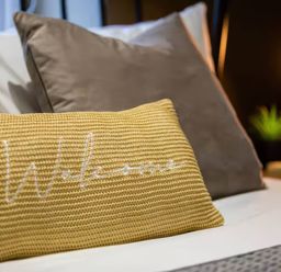 A bed with pillows and a lamp at White Willow Apartment in Llanrwst