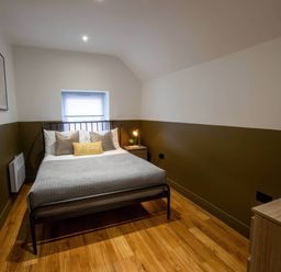 A bedroom with a bed and nightstand at White Willow Apartment Llanrwst