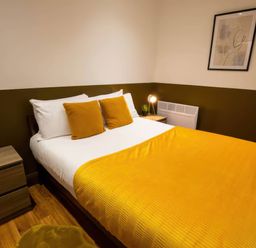 A bedroom with a bed and bedside table at Oakwood Apartment in Llanrwst