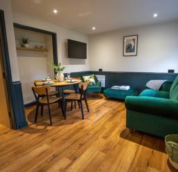 A living room with a dining table and sofa at Ash Cottages Llanrwst