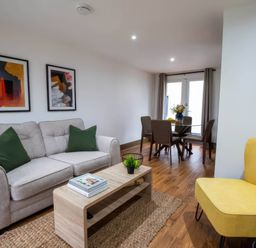A living room with a sofa a coffee table and a dining area at Beech Cottages Llanrwst