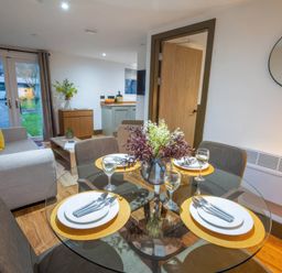 A dining area with a table set for meals at Fir Cottages in Llanrwst