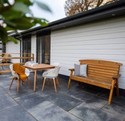 An outdoor patio with a wooden table and chairs at Silver Birch Cottage Llanrwst