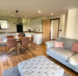 A kitchen with a dining table and sofa at River View Cottage in Llanrwst