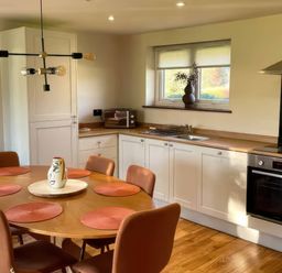 A kitchen with a dining table and chairs at River View Cottage Llanrwst