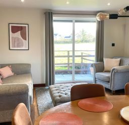 A living room with a sofa and an armchair at River View Cottage in Llanrwst