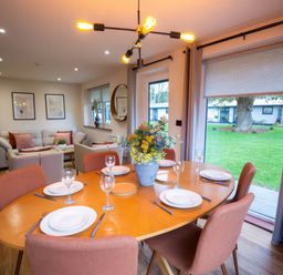 A dining room with a table set for four people at Mountain View Cottage in Llanrwst