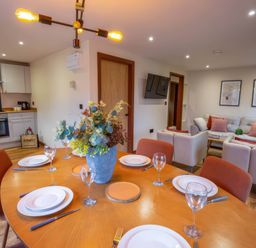 A dining room with a table set for meals at Mountain View Cottage in Llanrwst