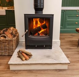 A fireplace with logs and basket in a living room at Fairview in Darsham