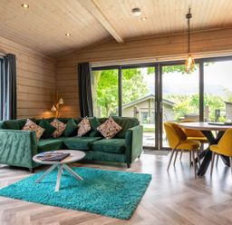 A living room with a green sofa and a dining area at Middleham (Pet) Leyburn