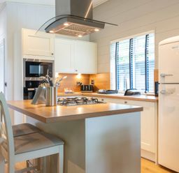 A kitchen with appliances and seating at Bainbridge in Leyburn