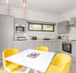 A kitchen with gray cabinets and yellow chairs at Leyburn (Pet) Leyburn