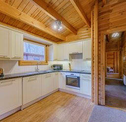 A kitchen with cabinets and a window at Maple Lodge in Louth