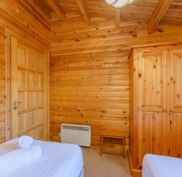A bedroom with a wardrobe and towel at Maple Lodge in Louth